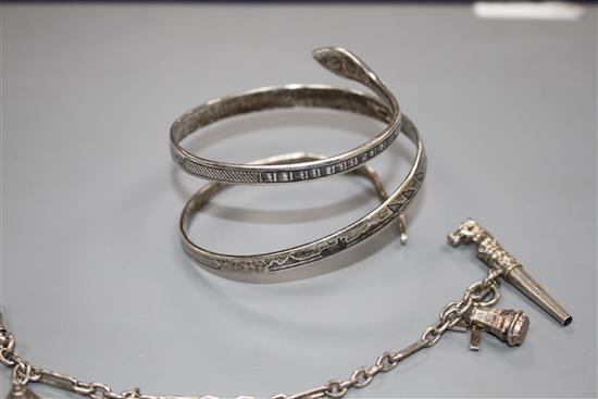 A modern silver and niello serpent bangle and a white metal tassle bracelet hung with four assorted charms, gross weight 65 grams.